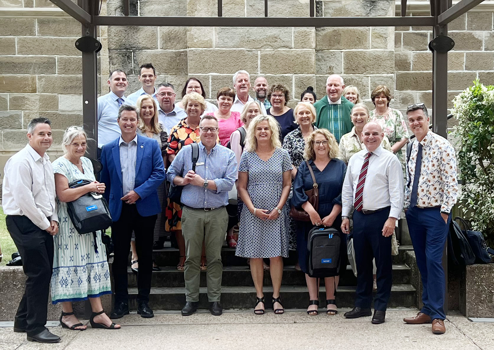 Adults standing together on school grounds, representing staff connection, collaboration and shared commitment within the school community